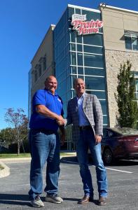 Dairy farmer and Board Director, Frank Doll, shakes hands with CEO/EVP, Matt McClelland, outside Prairie Farms Edwardsville, IL headquarters