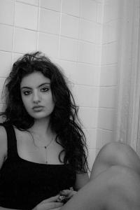 Adeline leaning against a wall, seated on the floor