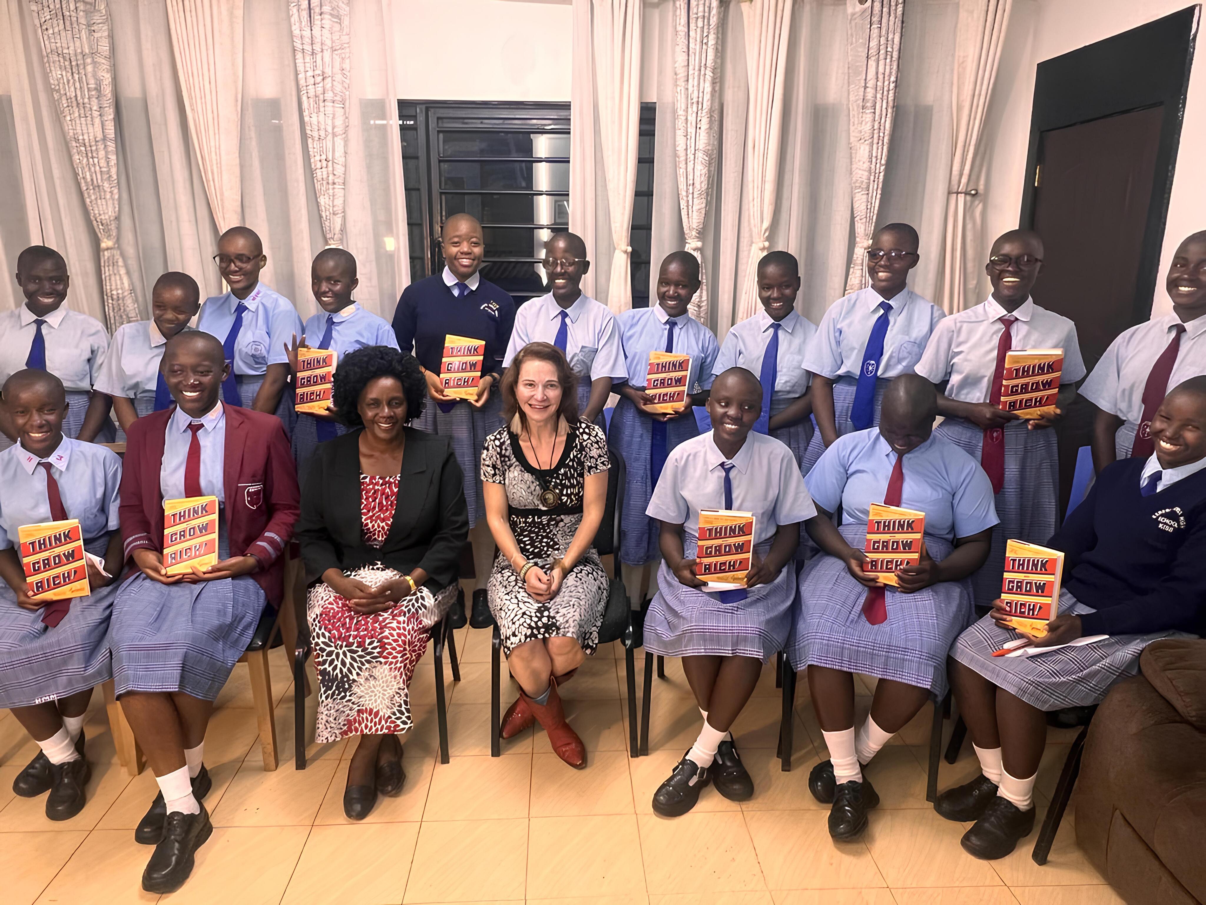 Group photo of M Teresa Lawrence (center), President & Executive Director, The Trueness Project, with Md. Tabitha Mogonchi, DHL, Kereri Girls High School Chief Principal and select students contributing to a leadership book, during her trip to Kenya in Sept 2024.