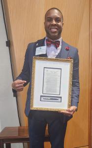 Dr. Michael C. Threatt pointing to and holding the signed 1974 Housing & Community Development Act at the 50th Anniversary of the Section 8 Program at the HUD Headquarters