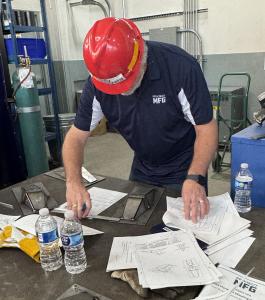 Judges check the competition projects and assess weld quality.