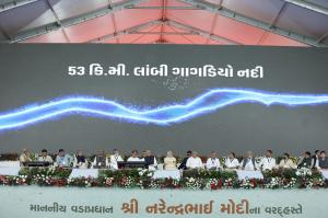 Prime Minister Modi with Savji Dholakia and dignitaries on stage at Bharatmata Sarovar inauguration.