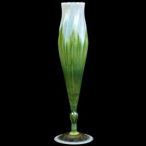 Lot 107 is a beautiful example of a floriform art glass vase signed L.C. Tiffany-Favrile (#1085d), 12 inches tall, white opal with a green pulled feather design. It is expected to finish at $2,000-$3,500.