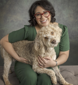 Dr. Tracey Maione, DVM, founder and owner of Oz Animal Hospital, smiling with her dog, showcasing a warm and welcoming demeanor, the same way she cares for pets and engages with clients.