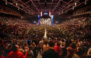 Interior view of the Watsco Center during the 2024 Conference of the Apostolic and Prophetic, featuring a sold-out arena filled with attendees engaged in the event.