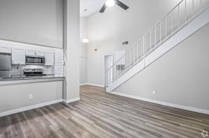 Aulden at the Highlands Apartments interior showcasing the open space, view into kitchen from the living room and the stairs to the second level. 