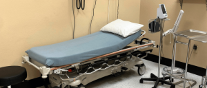 A hospital room with an adjustable bed, pillow, and medical equipment.