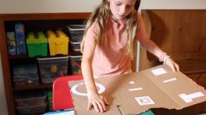 Girl using the ChompSaw to cut cardboard