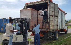 Haitian men are loading life-saving emergency food treatments for starving children in Haiti