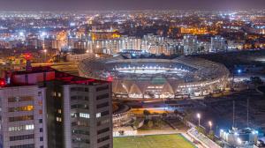 Night view of Martyrs Stadium in Benghazi, Libya, surrounded by buildings and city lights.