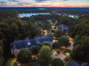 Aerial Image of the Apartment Community at Sunset, surrounded by trees with the city in the distance