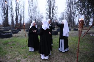 4 sisters, two are using sage bundles that are lit and emitting smoke to cleanse and clear the energies of the other 2 sisters