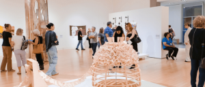 Visitors viewing art exhibits in a museum gallery.