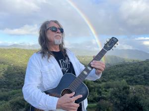 a photo of the artist holding his favorite guitar