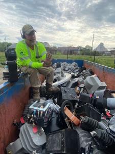 A man wearing a headset with a microphone demonstrates the industrial waste recycling process.