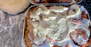 A pan of cinnamon rolls on a bakery counter