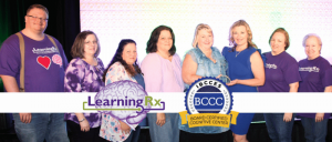Group of people on stage with "LearningRx" and "Board Certified Cognitive Center" logos.