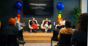 A panel of four speakers seated on stage with colorful balloon decorations in the background, addressing an audience at the Rainbow Ventures Summit.