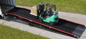 Forklift traveling from ground to semi-truck using portable yard ramps