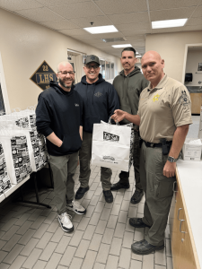 photo of four men from the Lost Hills Sheriff's Office in LA smiling and holding bags of sandwiches from Fat Sal's Deli