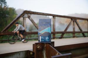 a bag of Organic Driftless Blend sits outside, bike in background