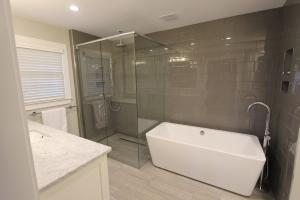 Modern bathroom remodel in Bellevue by BLC Remodeling, featuring a freestanding tub, frameless glass shower, gray subway tile walls, and marble countertop. Expert bathroom renovations and luxury upgrades for Bellevue and Greater Seattle.