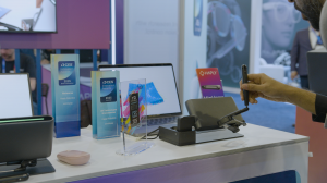 A trade show booth showcasing Haply Robotics' MinVerse, with CES 2025 Innovation Awards for "Best of Innovation" and XR Technologies. A hand interacts with the haptic stylus device, alongside a laptop display and branded materials.