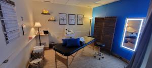 A tranquil spa room at Body Techs Wellness + Rehab, designed for cryo slimming treatments, fat removal, and skin tightening. The space features a comfortable treatment table, soft lighting, neatly arranged towels, and a calming ambiance to enhance relaxat