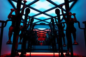 Group of people participating a fitness class with colorful lighting from suspended ceiling beams