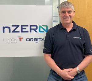 Mike Shepherd, Business Development Manager at nZero Group standing in front of sign with nZero Group logos