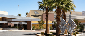 Exterior of the Desert Hot Springs Recreation Center, featuring palm trees and modern architectural design, with a metal sculpture in the foreground.