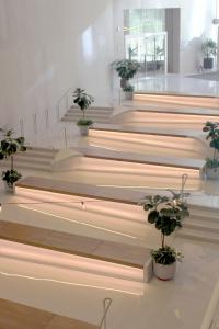 Precast terrazzo benches with wood accents are positioned along alternating gentle ramps.