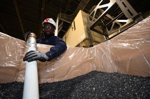 A man stirs a batch of specialty wax manufactured by GreenMantra Technologies.
