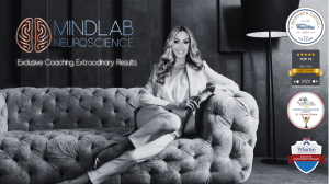 Dr. Sydney Ceruto seated on a luxurious couch, showcasing MindLAB Neuroscience branding and prestigious awards for excellence in life coaching and personal development.