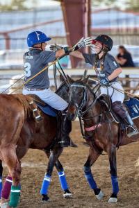 two arena polo players give each other a hug to celebrate their win