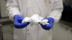 Scientist holding tissue paper light sheets of Aegis Fibretech materials