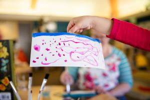 Preschooler holds abstract painting they created