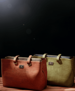 One army green tote bag and other brick red tote back from Ittara Bags in front of Black Background