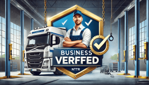A professional banner for NTTRDirectory.com's Business Verification Program, featuring a bold shield with a checkmark symbolizing trust and authentication. A skilled diesel mechanic in uniform is prominently displayed, working with tools in a workshop set