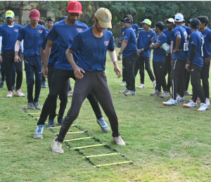 Young Baseball players at Diamond Dreams Academy, engaged in performing agility drills on a grass field