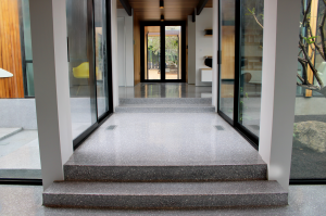 Terrazzo design: flooring on walkway in a modern home design between two glass atriums.