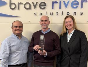 Brave River Solutions CTO Vin DiPippo, President Jim McAssey, and Director of Operations Rebecca Arsenault pose with the Best and Brightest award.