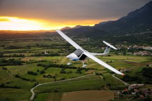 The Pipistrel Alpha electric 2 seat aircraft flying over a valley