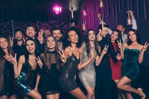 Group of young adults celebrating at a nightclub during a Las Vegas club crawl organized by Nocturnal Tours.