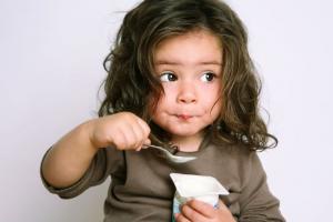 Child eating yogurt to help boost immune health.