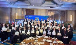 This image shows a large group of professionally dressed people at a graduation event. The participants are arranged in three rows, with many their Certified Residential Specialist Designation certificates. They are gathered in a formal hotel or conferenc