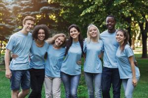 Group of people wearing baby blue custom t-shirts in a park.