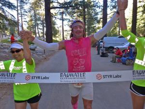 Frank McKinney crossing the finish line with supporters at the Badwater Ultramarathon.