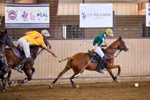 two arena polo players on horses one with the ball, one defending during United States Arena Handicap