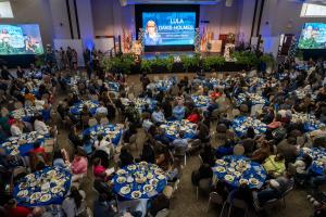 City of Carson California State of the City Event, Carson Mayor talking on stage with a room full of people sitting at round tables